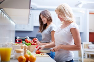 Portrait of happy mother and her daughter cooking in the kitchen